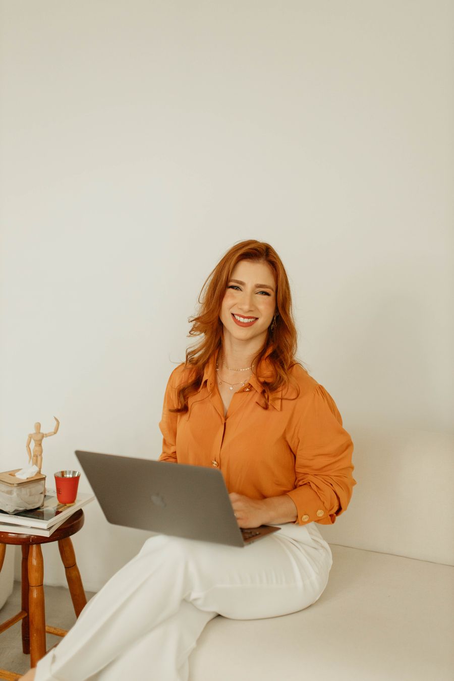 Marina Serejo sorrindo, sentada com um notebook no colo